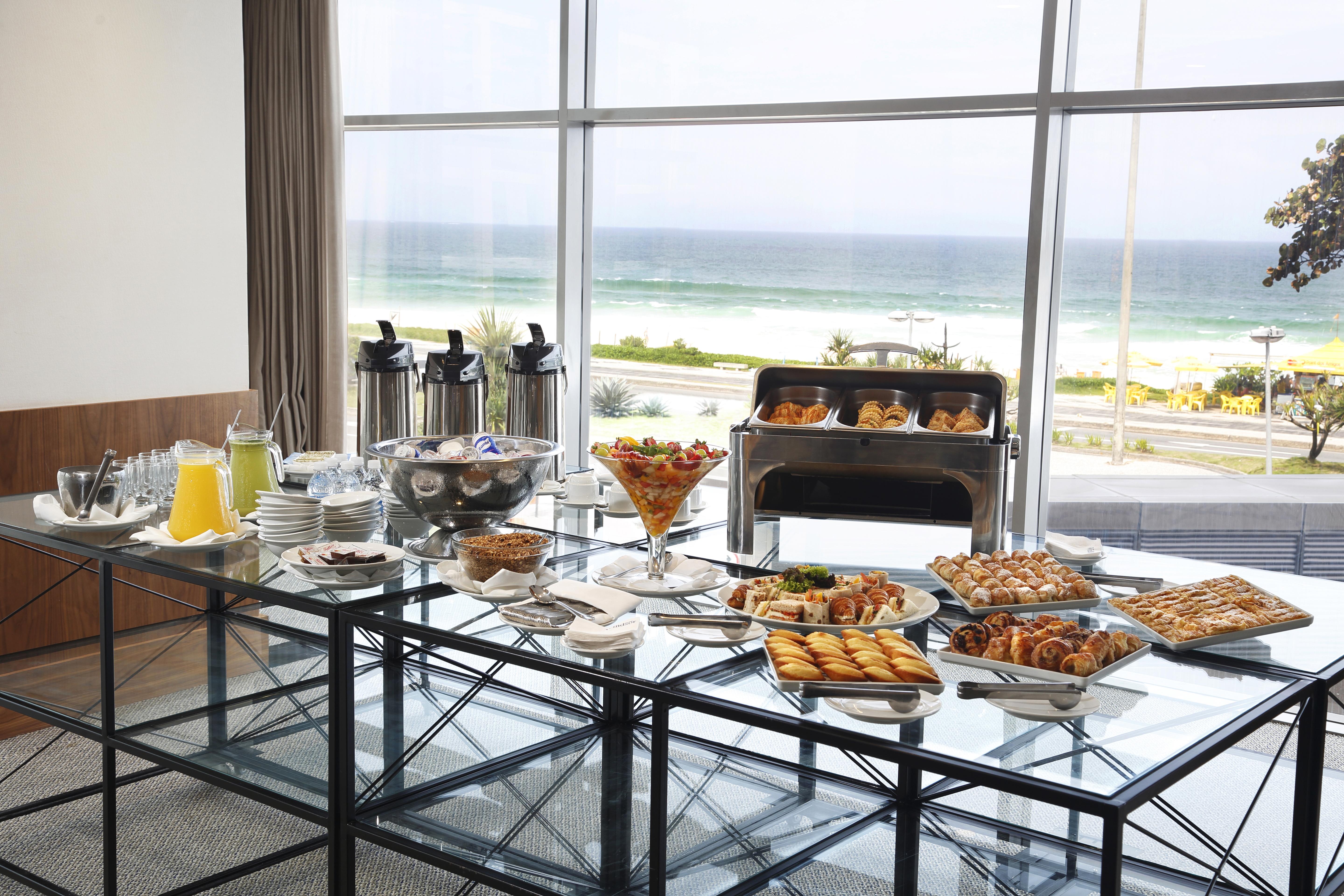 Windsor Marapendi Hotel Rio de Janeiro Exteriér fotografie The photo shows a beautifully arranged buffet table with a variety of food items. In the foreground, there are multiple plates and bowls filled with different dishes, including pastries, fruits, and savory items. There are also drinks available, such